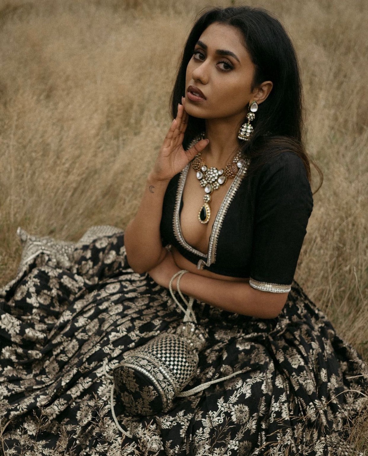 South Asian model in a black-and-gold lehenga, outdoor occasionwear shoot